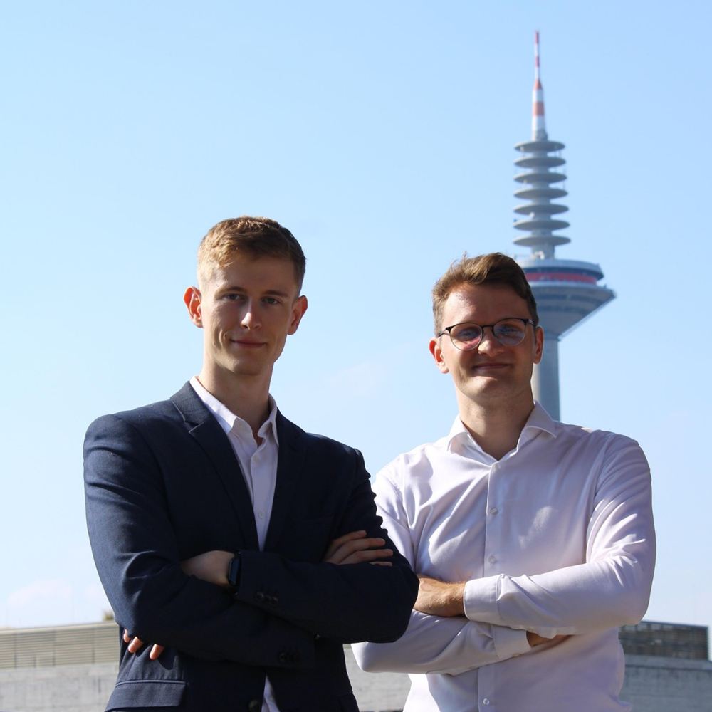 Die Gründer Steven Siebert und Lars Weidner auf einer Terrasse in Frankfurt, im Hintergrund der Europaturm